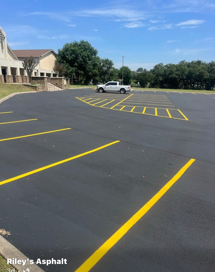Fresh black asphalt parking lot with yellow striping